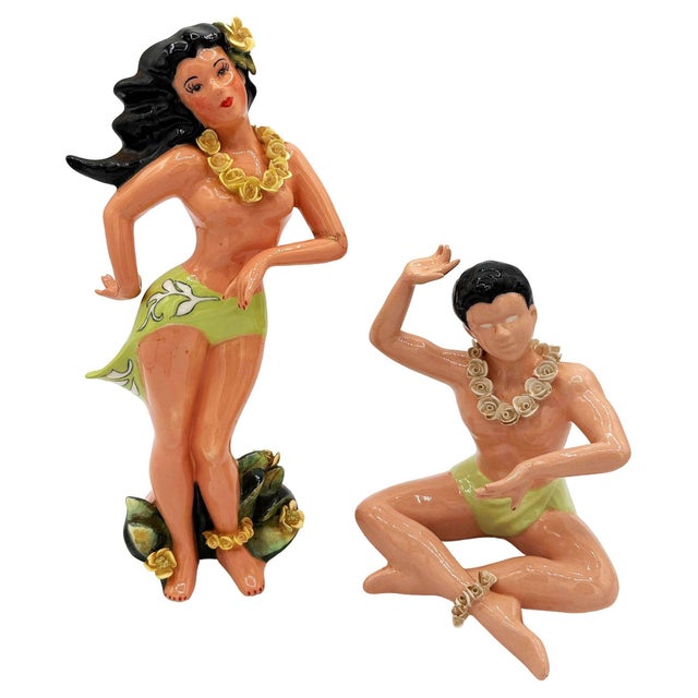 This pair of vintage mid-century ceramic figurines depicts a stylized Polynesian man and woman. Hand-painted with a glossy...