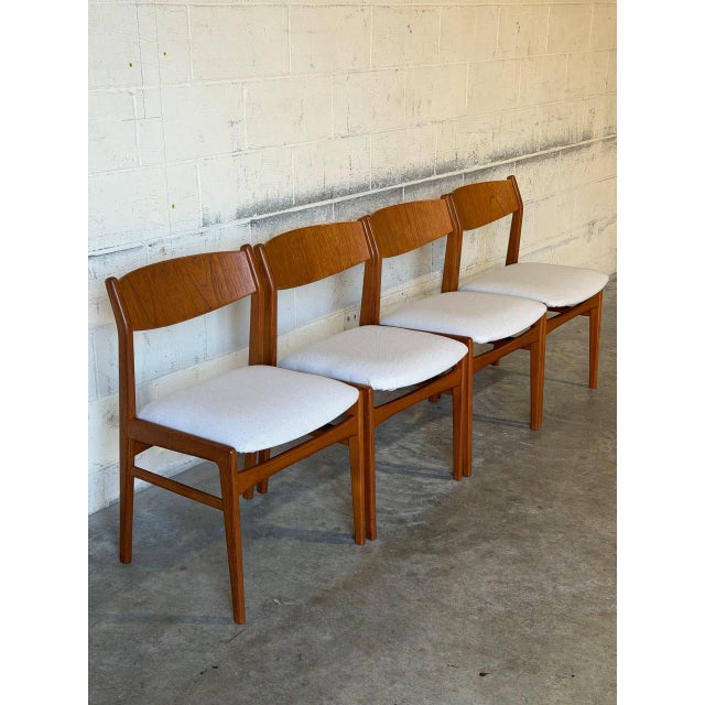 This set of four dining chairs features gently curved teak backrests and clean architectural frames. Their open silhouette...