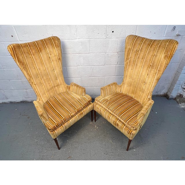Elegant pair of mid-century high-back chairs featuring a refined silhouette and comfortable upholstered seats. Their tall,...