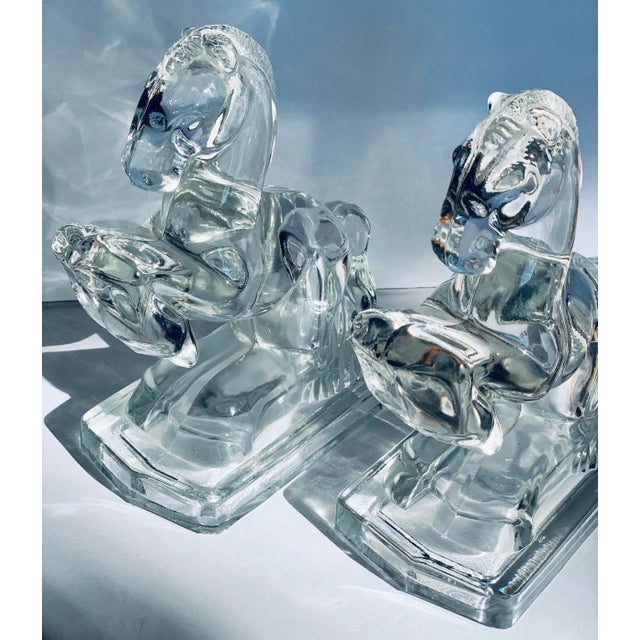 A pair of noble, rearing equine bookends fashioned in solid glass. Made in the Art Deco style in the 1940s-1950s by The...