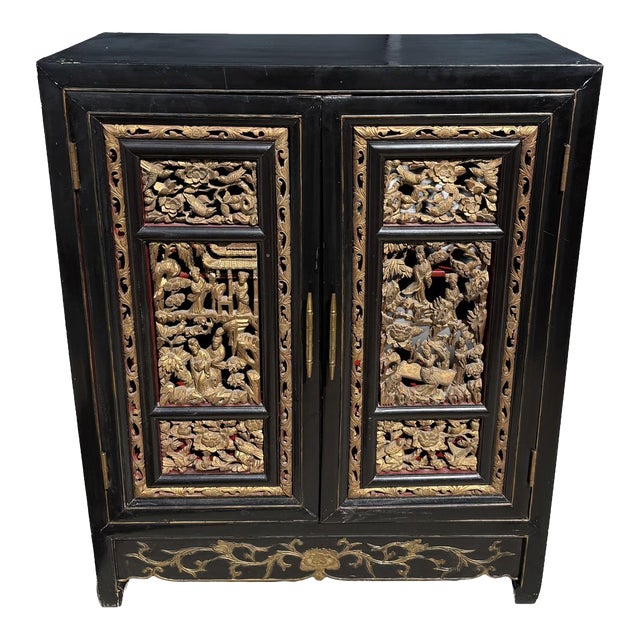 Late 20th Century Heavily Carved Black Asian Cabinet With Gold Doors and Red Interior For Sale