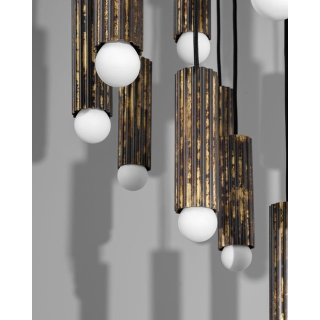 Thirty-two fluted solid brass cylinders are suspended in diamond formation, and a constellation hovering in space. From...