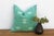 A single star motif and a slim dashed-line border trace the corner of this handcrafted Moroccan cactus silk pillow, hand-...
