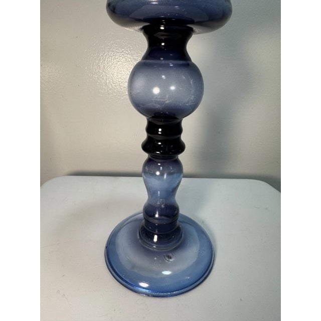Add a touch of vintage elegance to your home with this beautiful blue glass pedestal candle holder. Featuring a classic...