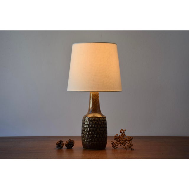Ceramic table lamp manufactured by Søholm Stentøj, Denmark, circa 1960s. It features a shiny brown glaze on a textured...