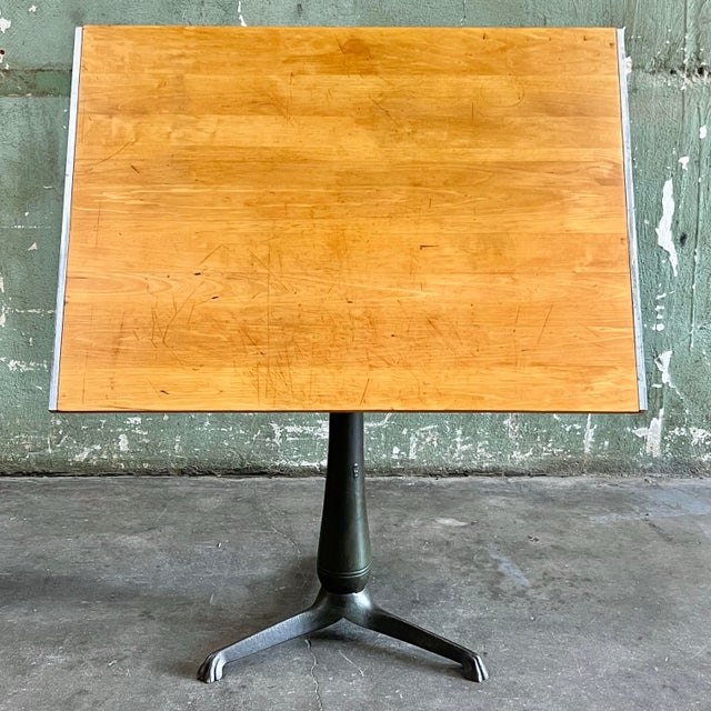 Beautiful antique drafting table with a heavy cast iron pedestal base. The solid maple top has been restored; sanded up to...