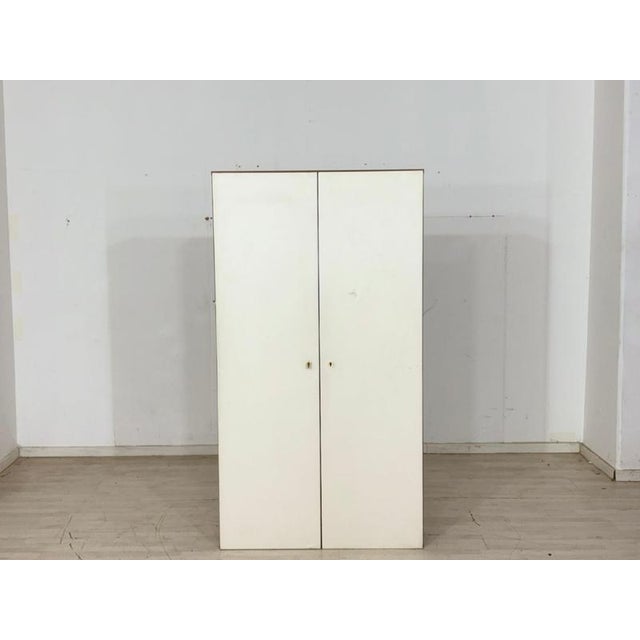 Spacious and functional vintage shoe cabinet from the 1960s. Behind the minimalist white double doors lies a well-designed...