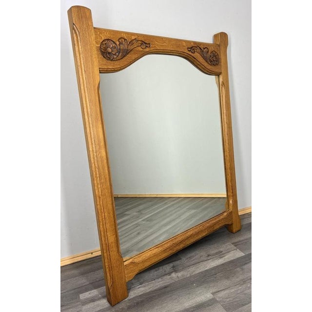 A beautifully crafted Vintage French mirror, featuring a solid oak frame with elegant carved floral and scroll motifs. The...