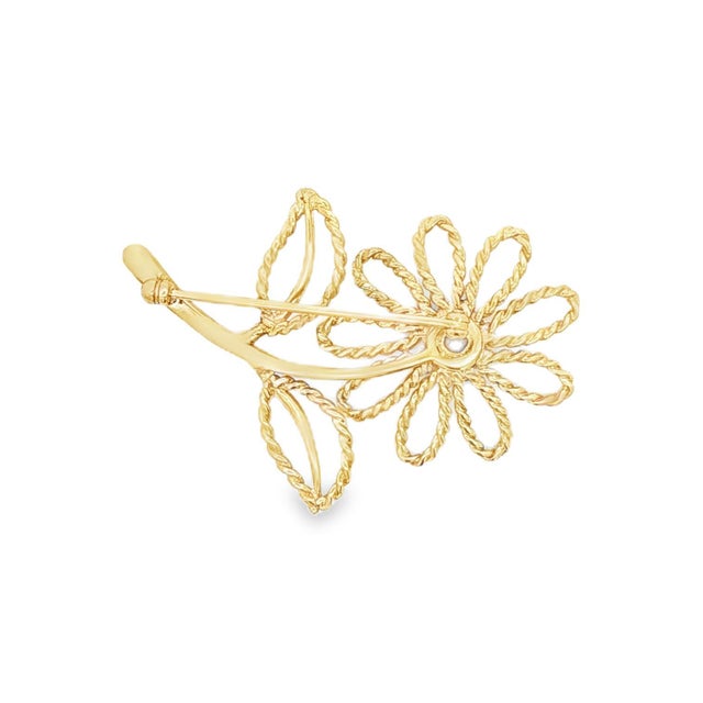 A 1960s 14k gold flower brooch. Features a delicate twisted wire design forming petals and leaves. The center showcases a...