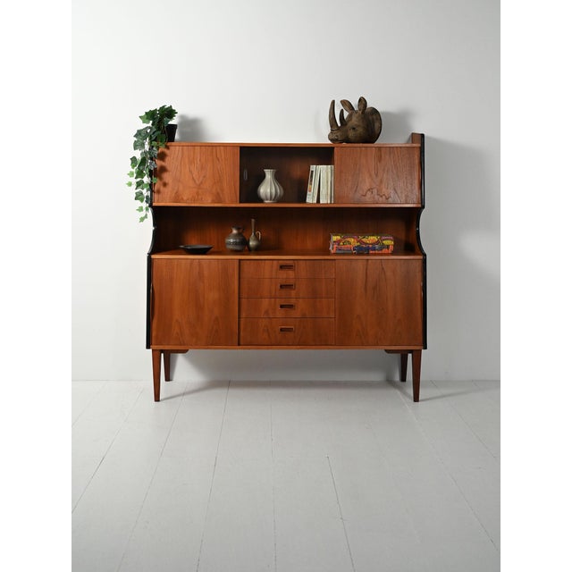 Scandinavian teak sideboard from the 1950s. Central drawers with recessed handles, spacious two-level storage, and an...