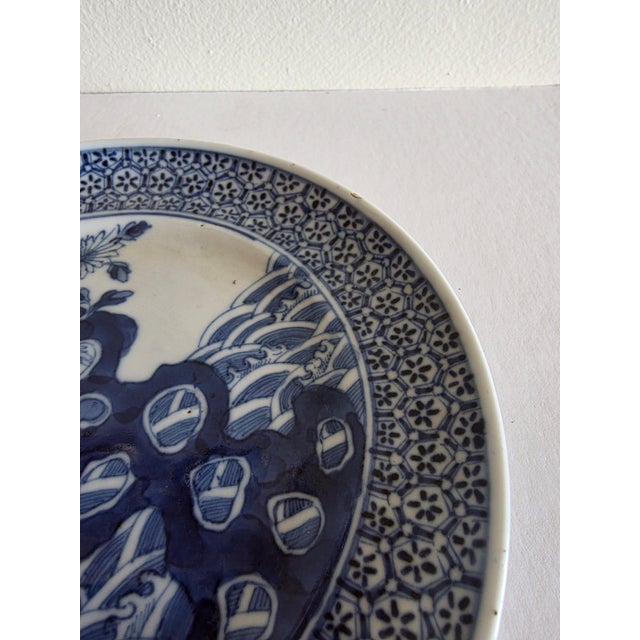 Pair of antique Chinese Blue and white plates featuring a hawk on a rock formation and a hexagonal diaper border.
