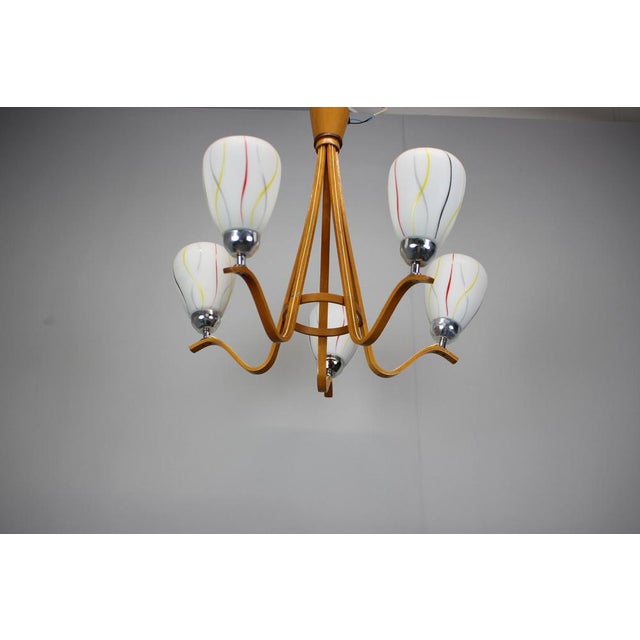 A mid-century chandelier crafted in Czechoslovakia during the 1970s, featuring a bentwood structure combined with...