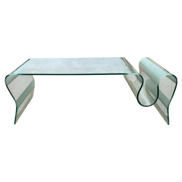 Sleek, sculptural, and effortlessly modern — this bent glass coffee table is a statement piece of contemporary design....