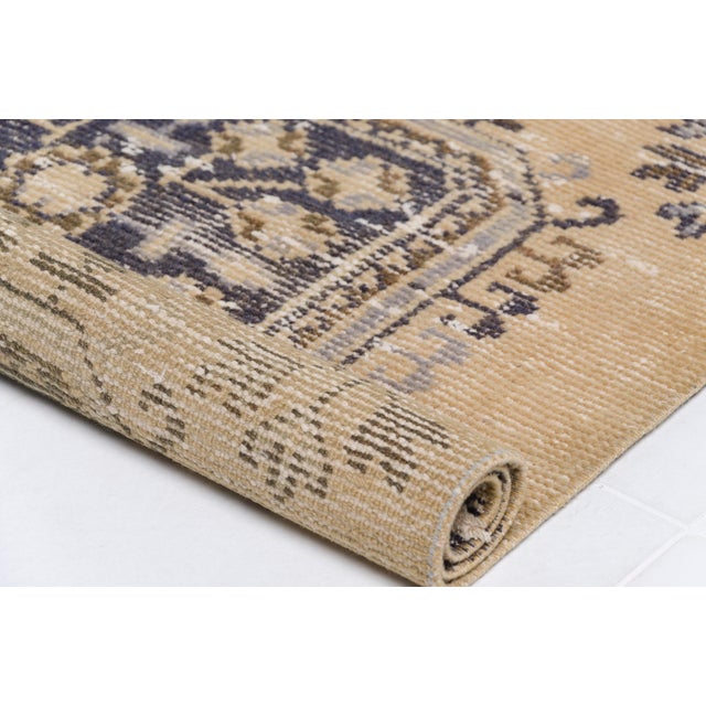 This is a vintage Turkish Oushak rug from the Mid 20th Century. The piece was hand-knotted.