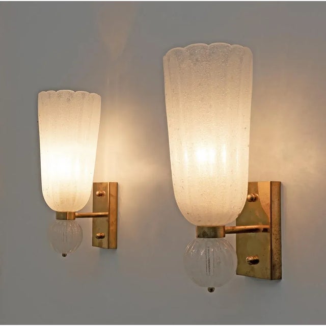 Beautiful set of two stunning brass wall lamps made with brass base and white "pulegoso" blown murano glass glasses in the...