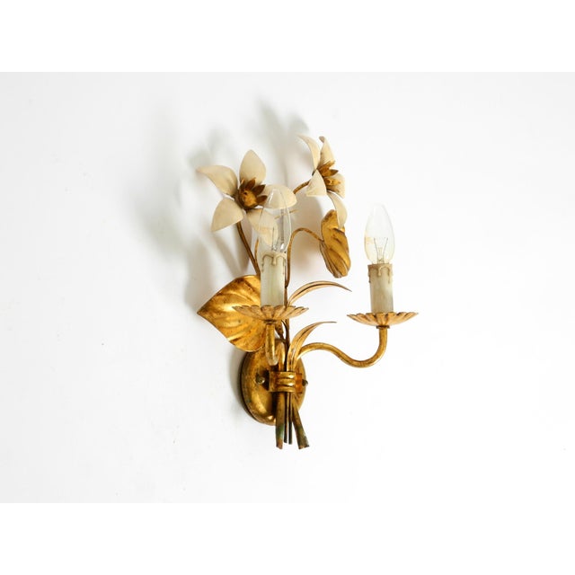 1960s gold-plated Florentine wall lamp with two sockets. Beautiful design with many details. The beige leaves are hand-...
