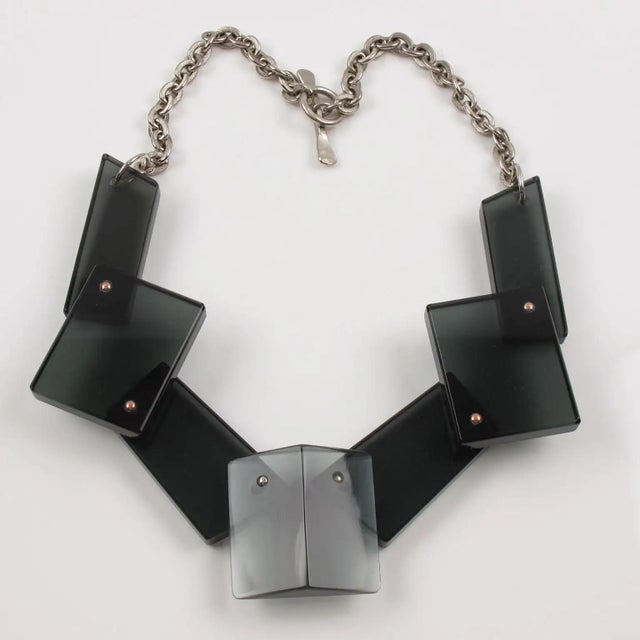 This stunning modernist choker features a handmade geometric bib necklace. Each extra-thick block of Lucite is hinged,...