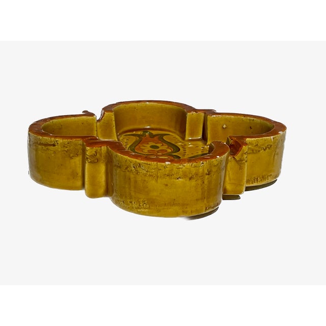 A vibrant and sculptural vintage Italian art pottery ashtray, featuring a unique lobed quatrefoil shape. This piece is...