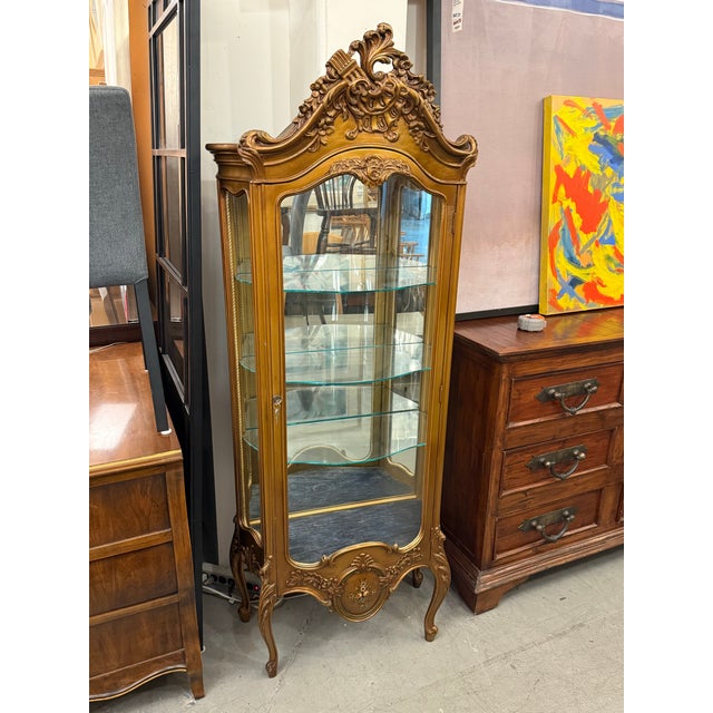 Design Plus Gallery presents a Vintage French Louis XV Style Giltwood Curio Display Cabinet. This ornate cabinet showcases...