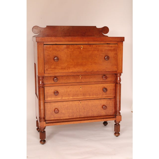 American empire cherry wood chest of drawers, circa 1830. With a back splash with circular ends, a large top drawer, 3...