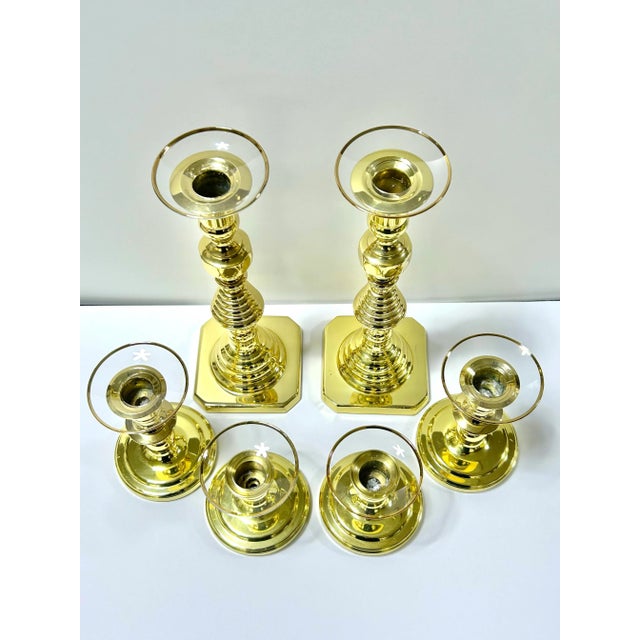 A substantial set of six Baldwin brass candlesticks featuring classic turned silhouettes and removable glass bobeches to...