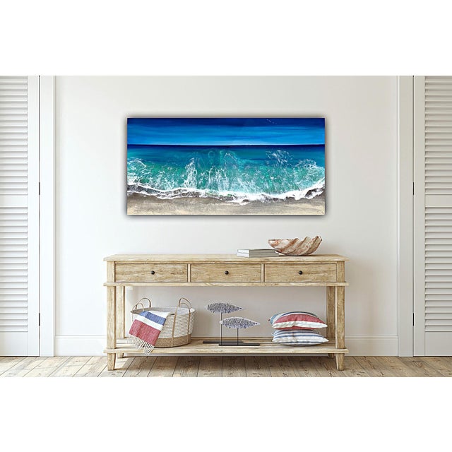 This mixed media artwork captures the dynamic movement of ocean waves, with a vibrant interplay of blues and greens that...