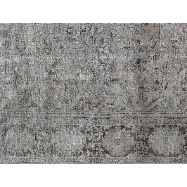 This Vintage Persian Meshed Overdyed Rug is hand-woven with wool on a cotton foundation in Iran. It has been refinished...