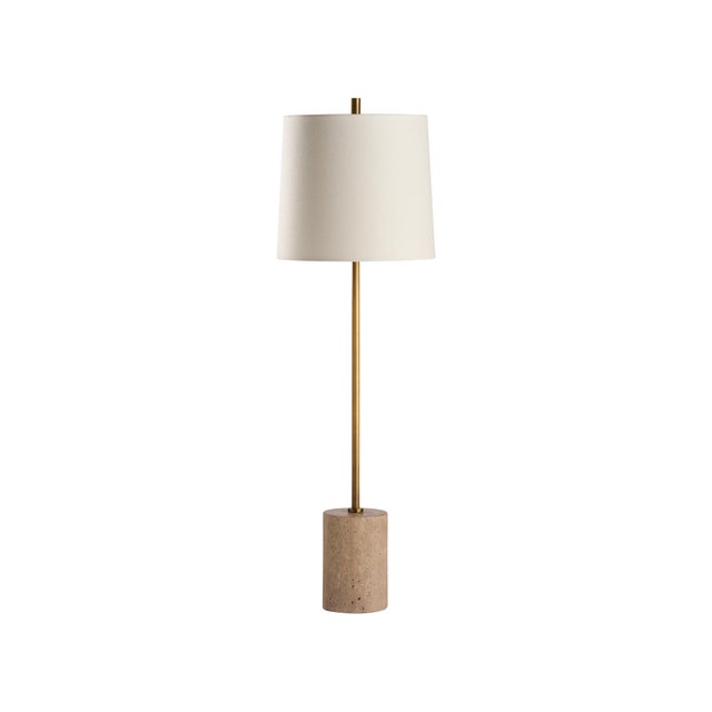 This contemporary lamp features a travertine base accented by a sleek metal body in a rich gold finish. Its minimalist...