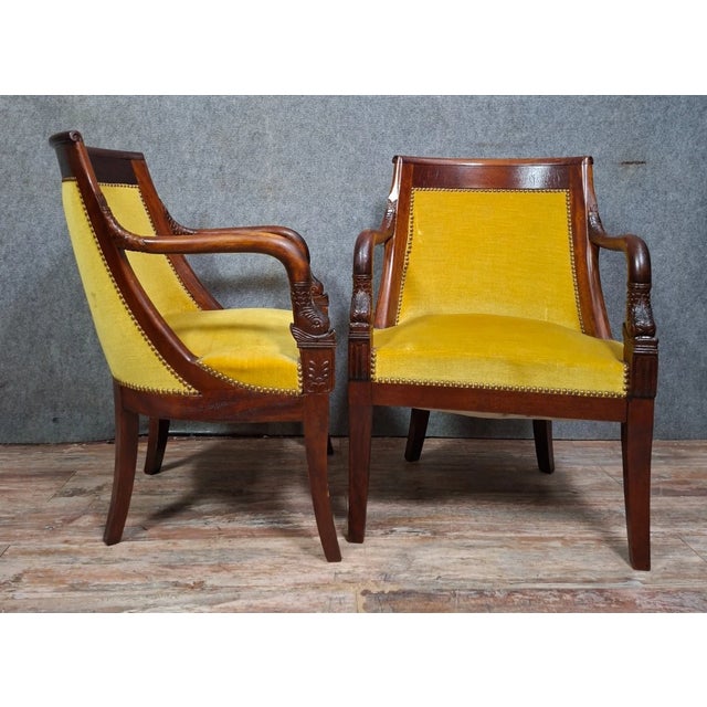 Pair of Empire style mahogany armchairs with dolphin motifs – 19th century An elegant pair of Empire style armchairs in...
