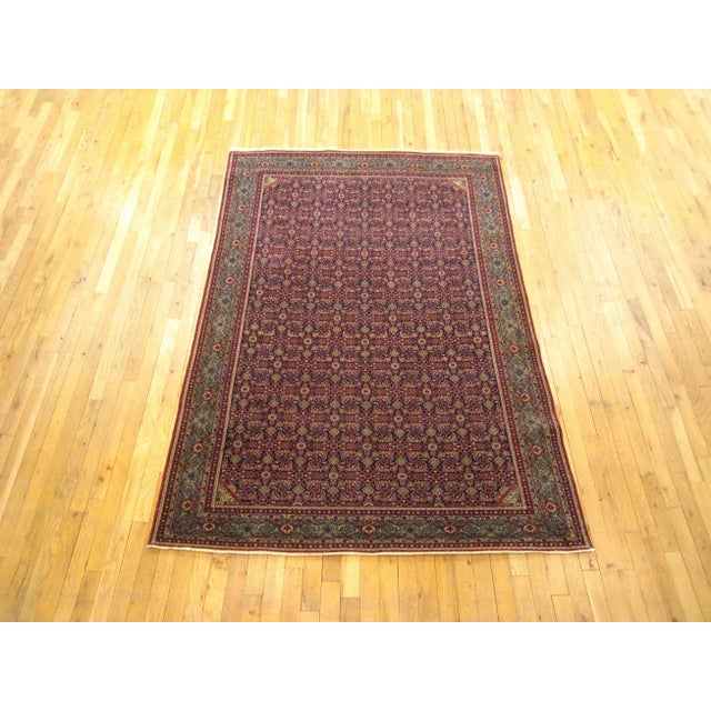 An antique Persian Tehran oriental carpet, circa 1920. This fine handwoven rug features a handsome repeating Herati design...