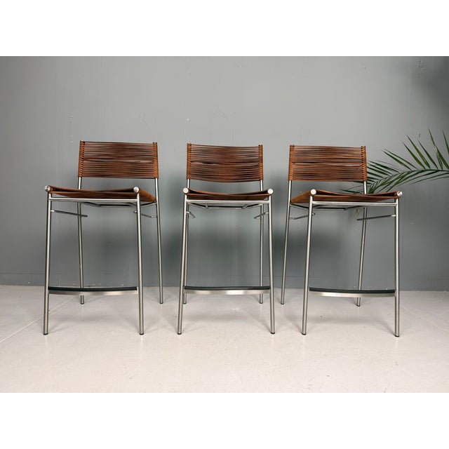 A refined set of three miss b classic bar stools designed by tito agnoli. This iconic italian design was originally...