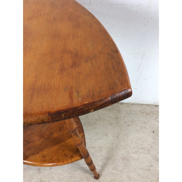 This mid century accent table features hardwood construction, two tier design, and turned wood legs in a bamboo style.