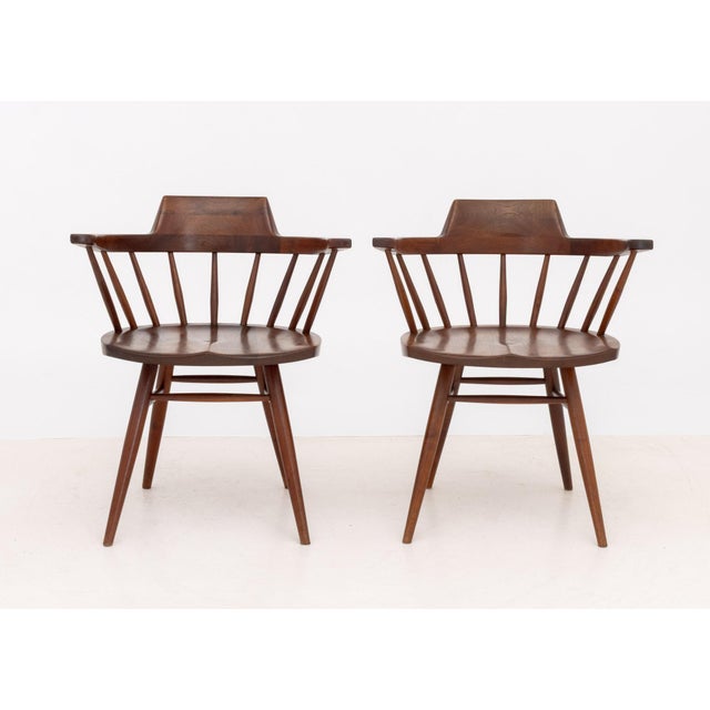 Pair of George Nakashima (American, 1905-1990) American Walnut Captain's Armchairs, 1962, with spindle backs on turned...