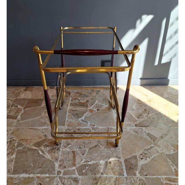 A beautiful serving or bar cart crafted from brass, glass, and wood, often attributed to Cesare Lacca. A dynamic and...
