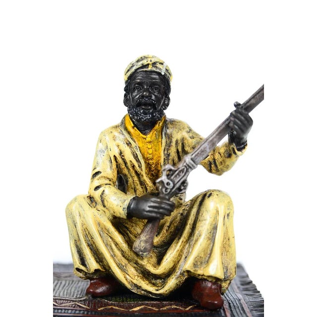 Cold painted Austrian bronze figure of an Arab warrior on a rug holding his rifle from the c1900s. A beautiful piece that...