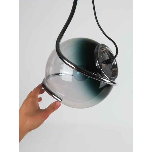 A Space Age Pendant made in Italy between the 1960s and 1970s composed of a sphere in Murano glass shaded from teal to...