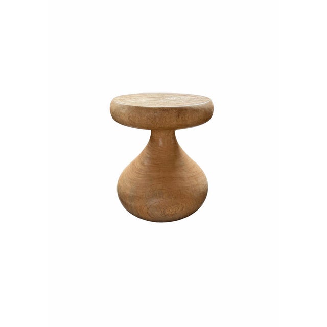 This solid mango wood side table is defined by a beautifully flowing, sculptural form—reminiscent of a single drop of...