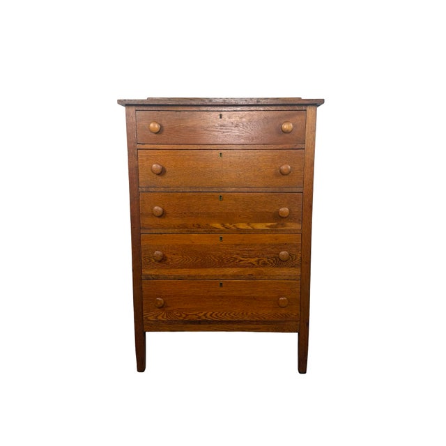 A handsome antique oak tall chest dating to the early decades of the 20th century, this five-drawer piece combines...