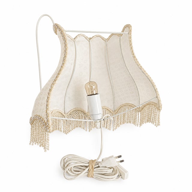 A pair of Swedish wall sconces from the 1960s, featuring scalloped fabric shades in soft cream with a delicate floral...