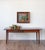 A charming antique French farmhouse table featuring a beautifully weathered plank top with a warm, honey-brown patina and...