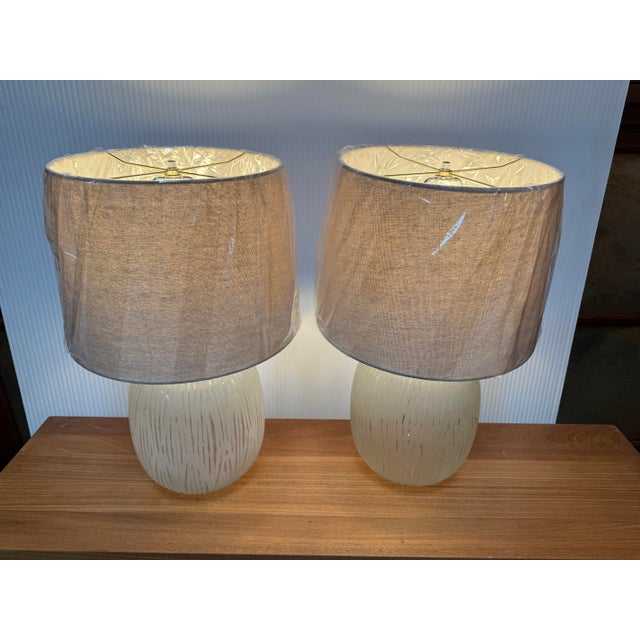 Design Plus Gallery presents a Pair of Etched Glass Table Lamps. The lamps have a frosted glass body with etched treatment...