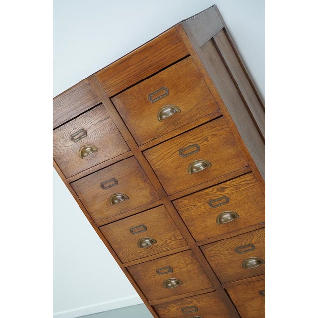 This apothecary / filing cabinet was produced during the 1930s in the Netherlands. This piece features 12 large drawers...