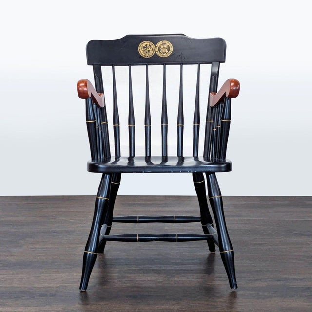 This elegant black Windsor chair features gold detailing and a unique gold emblem on the backrest. The arms are finished...