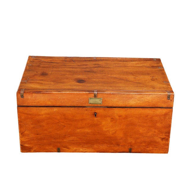 A British officer's campaign trunk from the 1830s in mahogany, built for maritime service with brass strap reinforcements...