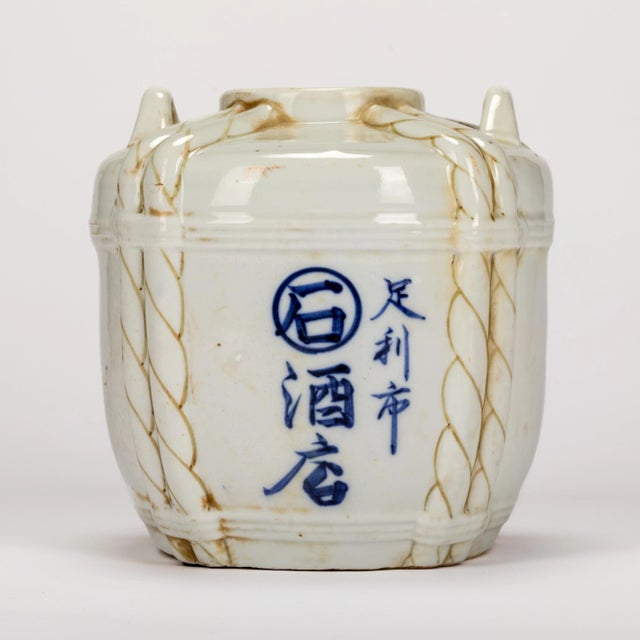 Vintage Asian vessel with rope detail and Chinese characters. Open top, approximately 3" diam and an opening towards the...