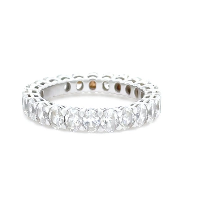 An exquisite 18ct white gold diamond eternity ring, featuring 24 oval brilliant-cut diamonds meticulously claw-set in a...