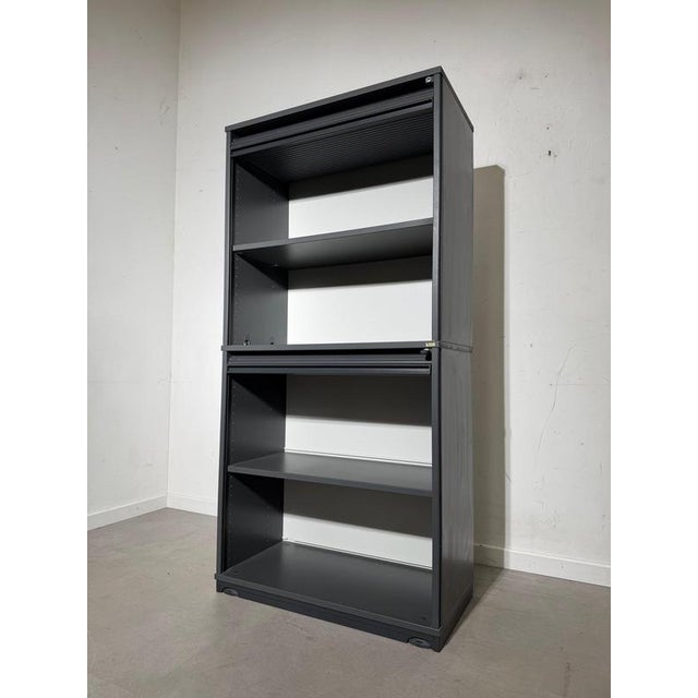 Functional and timeless tambour door cabinet by Kinnarps, finished in a sleek dark grey. This piece is designed for...