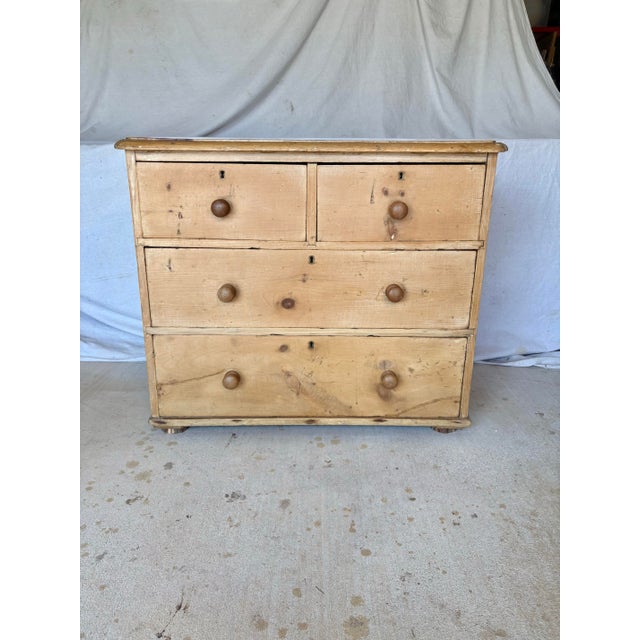 This 19th Century English Pine Chest of Drawers dates back to the late 1800's. The piece features a planked top resting...