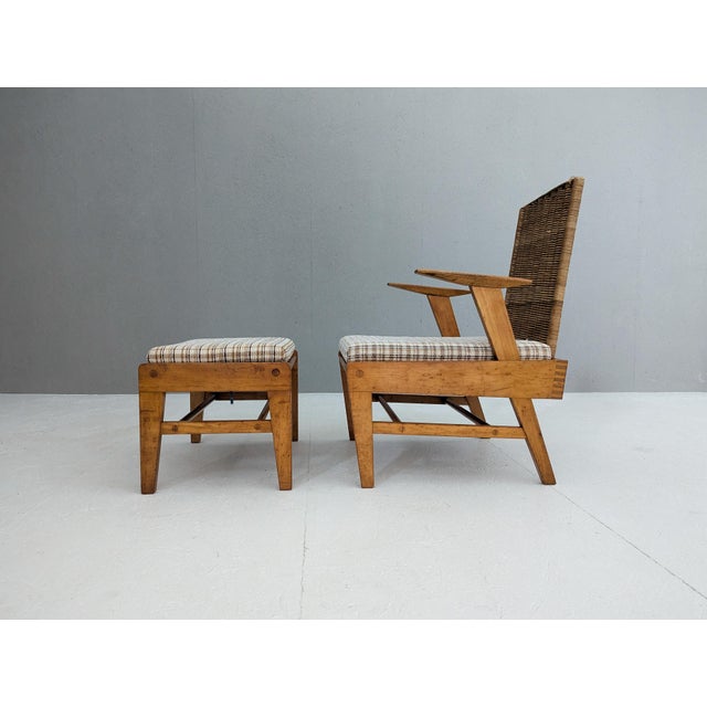 A striking example of mid-century czech craftsmanship, this sculptural beech and rattan armchair with matching footstool...