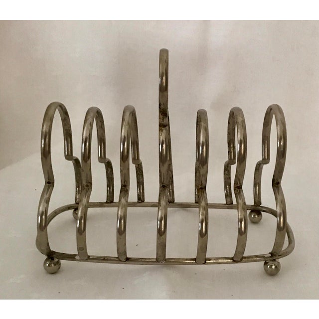 This listing is for an antique silver-plated 6-slice toast rack, featuring trefoil hoops and raised on ball feet. Perfect...